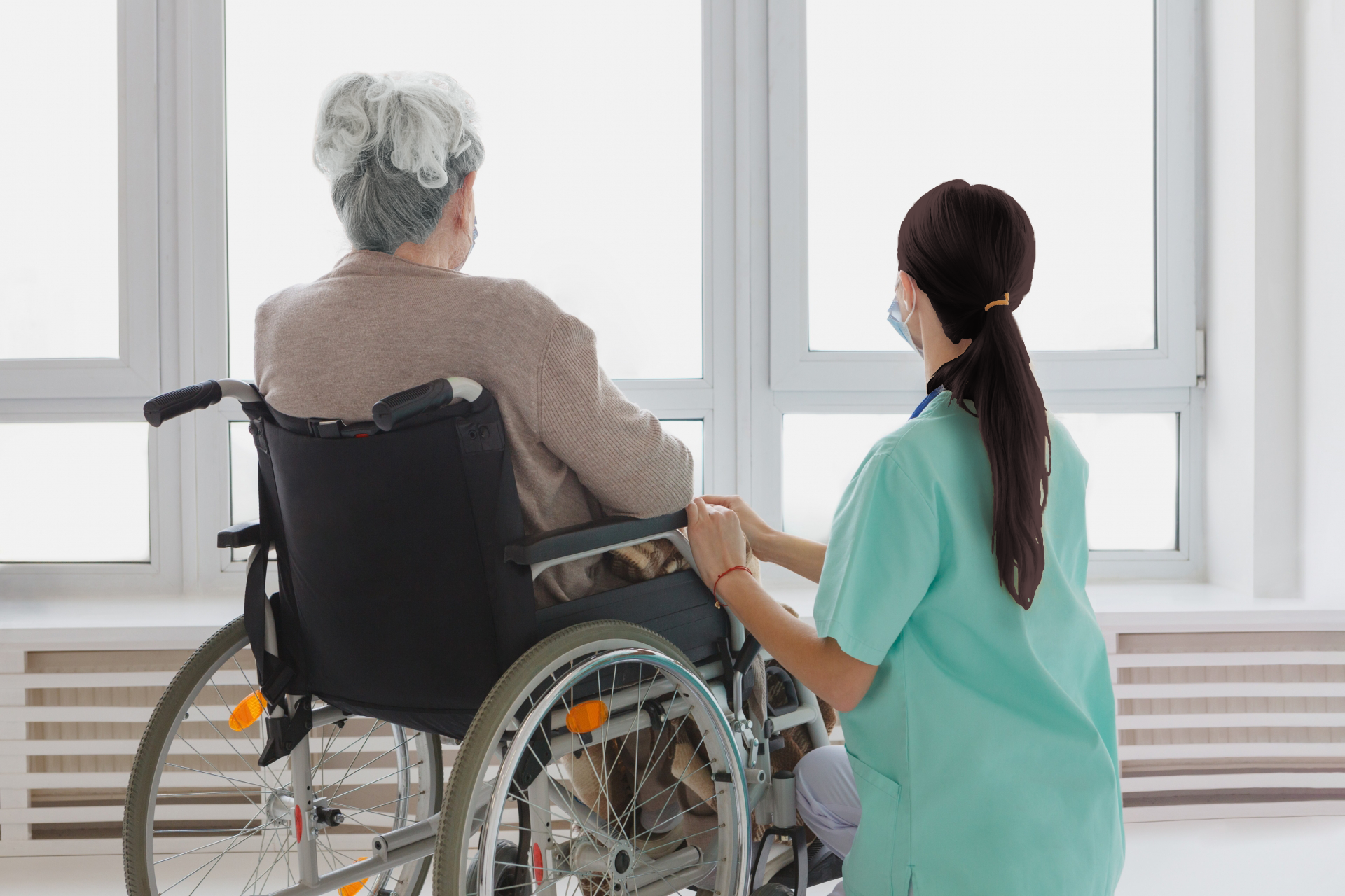 車いすの患者と支える看護師の画像